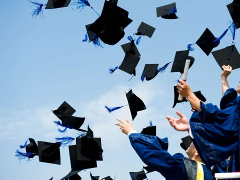 Graduation caps being thrown into the air